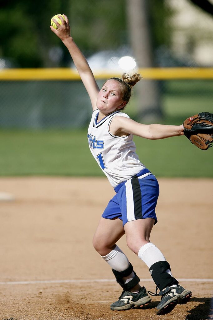 concentrated female softball pitcher throwing ball